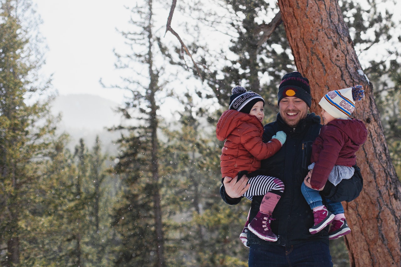 father carrying toddlers