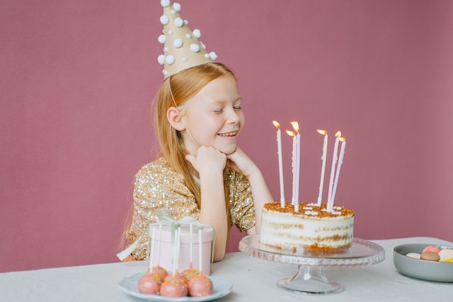 girl blowing out candles