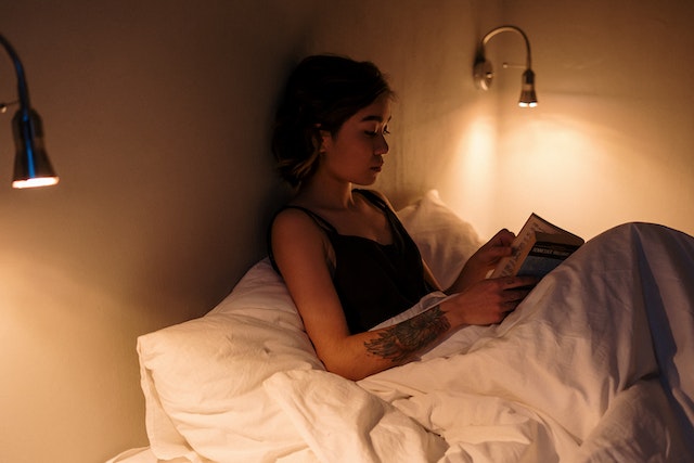 girl reading in bed